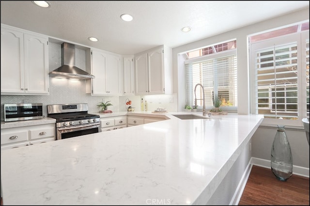 kitchen with a sink, wall chimney exhaust hood, tasteful backsplash, and stainless steel appliances