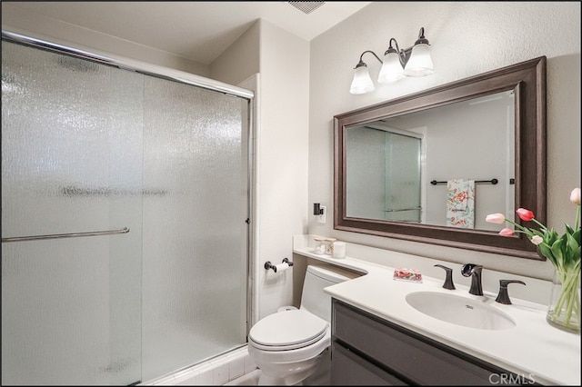 bathroom featuring vanity, toilet, and a shower stall