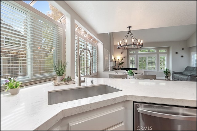 kitchen with a sink, plenty of natural light, dishwasher, and white cabinets