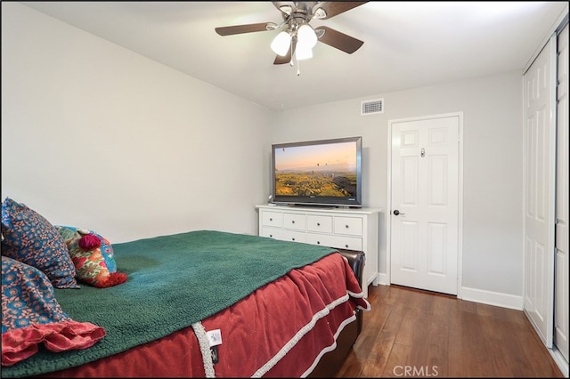 bedroom with dark wood finished floors, baseboards, visible vents, and ceiling fan