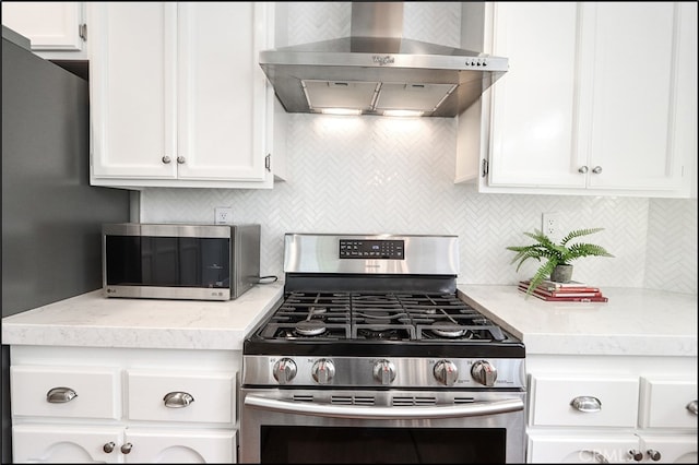 kitchen featuring white cabinetry, wall chimney exhaust hood, and stainless steel appliances