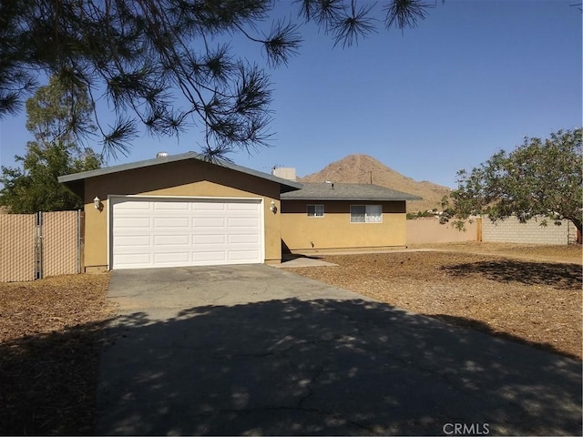 view of front of house featuring concrete driveway, fence, an attached garage, and stucco siding