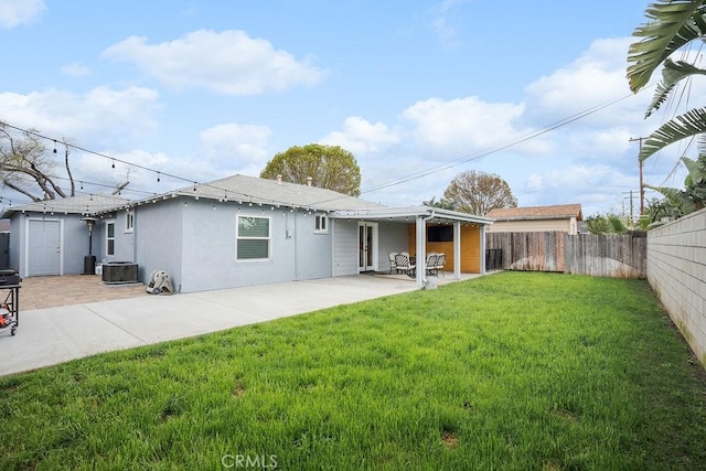 back of property with a yard, central AC, a fenced backyard, and a patio area