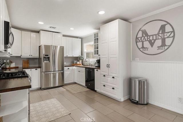 kitchen with visible vents, appliances with stainless steel finishes, white cabinetry, and a sink