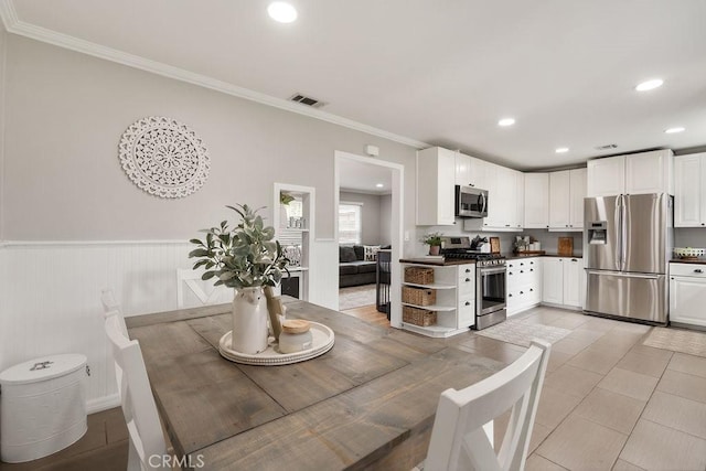 dining space featuring recessed lighting, visible vents, ornamental molding, and a wainscoted wall