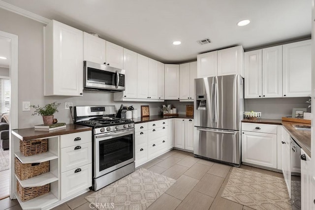 kitchen featuring dark countertops, visible vents, white cabinets, and appliances with stainless steel finishes