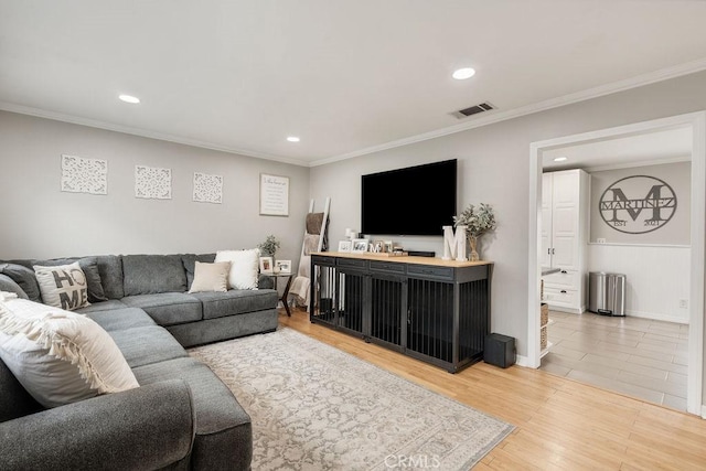 living room featuring light wood finished floors, visible vents, crown molding, baseboards, and recessed lighting