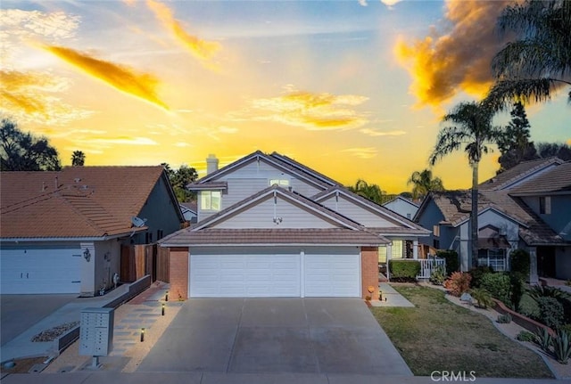 traditional home with concrete driveway, a garage, and brick siding