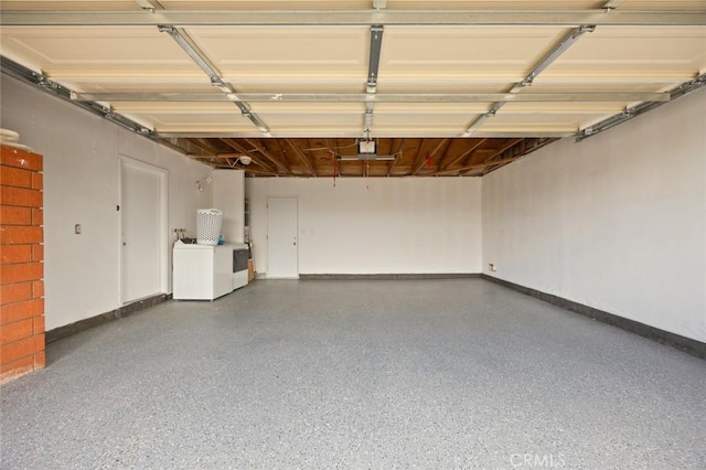 garage featuring baseboards and washing machine and clothes dryer