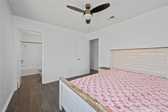 unfurnished bedroom with visible vents, ensuite bathroom, dark wood-type flooring, a textured ceiling, and baseboards