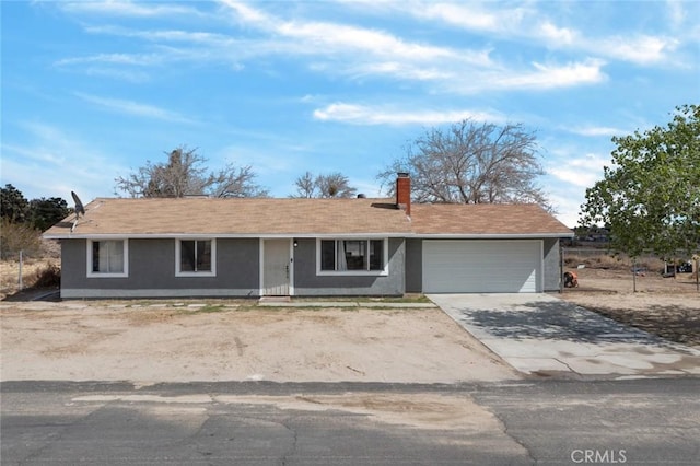 ranch-style house with a garage, concrete driveway, and a chimney