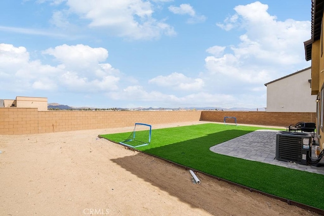 view of yard featuring a patio area, a fenced backyard, and central air condition unit