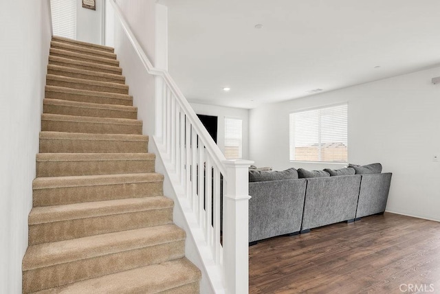 stairway with baseboards, wood finished floors, visible vents, and recessed lighting