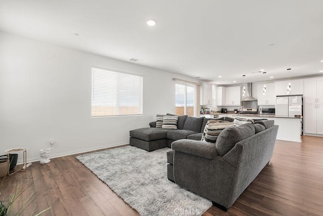 living area featuring recessed lighting, dark wood finished floors, visible vents, and baseboards