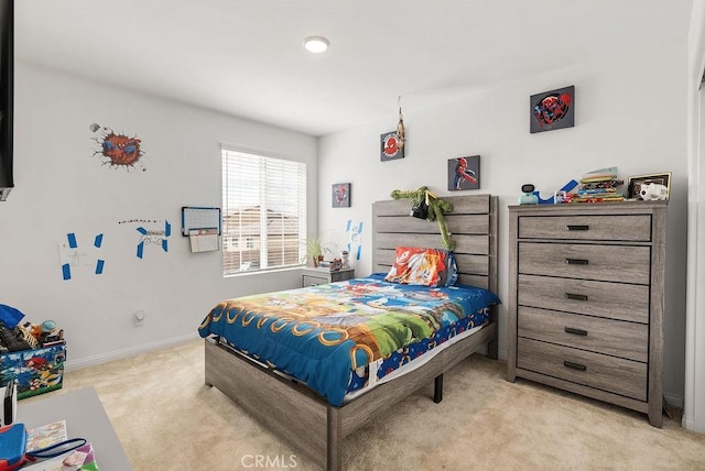 bedroom featuring light carpet and baseboards