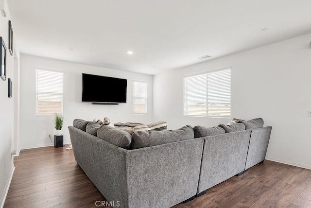 living area with visible vents, dark wood finished floors, and baseboards