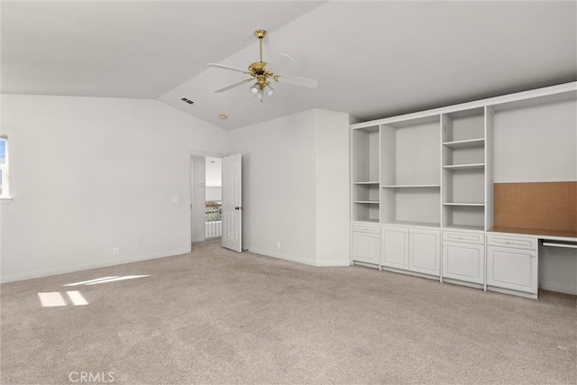 interior space with visible vents, baseboards, ceiling fan, vaulted ceiling, and light carpet