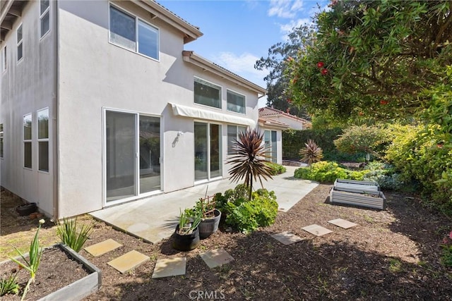 back of property featuring stucco siding and a patio