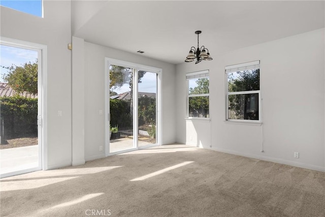 unfurnished room featuring a chandelier, visible vents, baseboards, and carpet