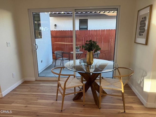 dining area featuring light wood-type flooring and baseboards