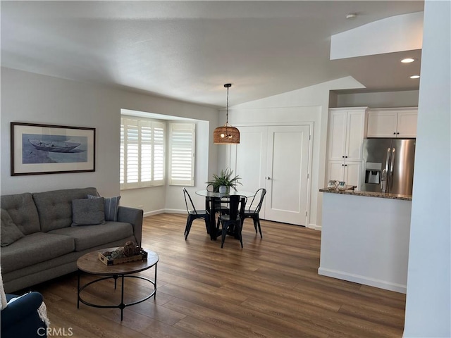 living area with dark wood-style floors, recessed lighting, lofted ceiling, and baseboards