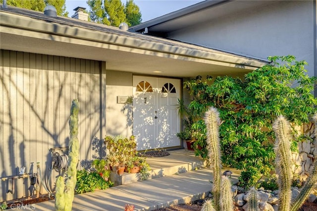 entrance to property featuring stucco siding