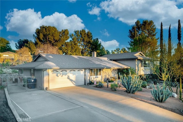 view of front of home featuring fence, stucco siding, driveway, an attached garage, and a gate