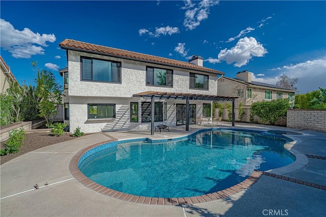 rear view of house featuring a patio, a fenced in pool, a pergola, a chimney, and stucco siding