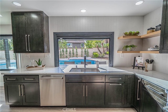 kitchen with light stone counters, decorative backsplash, light wood-style flooring, stainless steel dishwasher, and open shelves