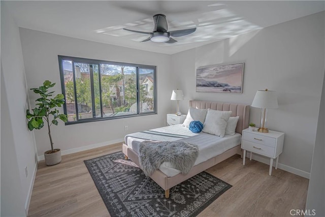 bedroom featuring ceiling fan, baseboards, and wood finished floors