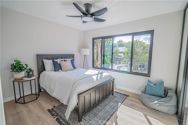 bedroom featuring ceiling fan, light wood-type flooring, and baseboards