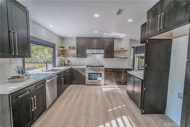 kitchen featuring open shelves, under cabinet range hood, a sink, appliances with stainless steel finishes, and light wood finished floors