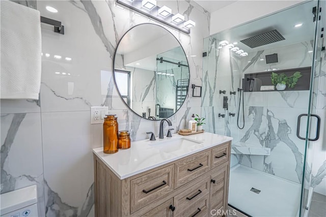 bathroom with a marble finish shower, tasteful backsplash, tile walls, and vanity