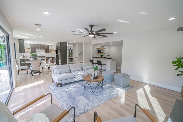 living room featuring recessed lighting, visible vents, baseboards, and light wood-style flooring