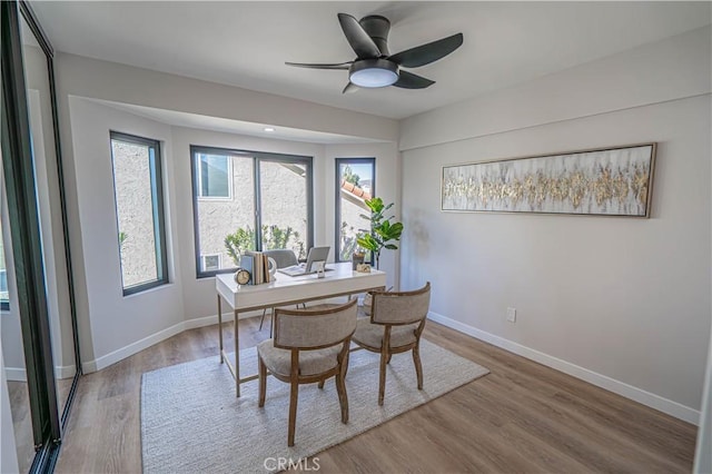 dining space with wood finished floors, baseboards, and ceiling fan