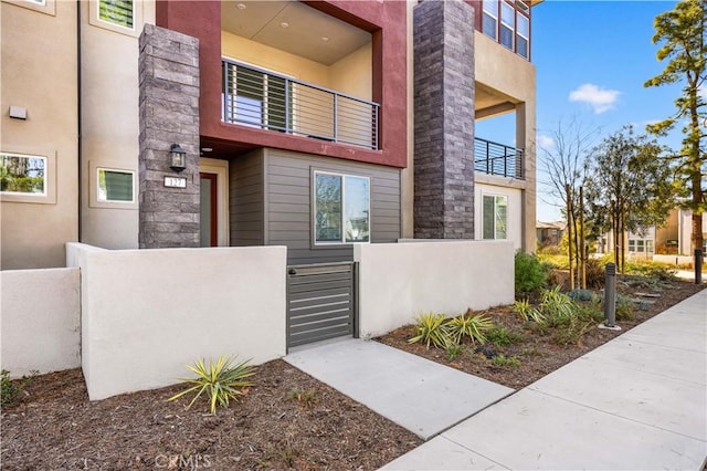 view of front of property featuring a fenced front yard, a gate, and stucco siding