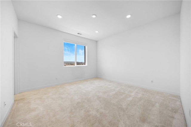carpeted empty room with visible vents, baseboards, and recessed lighting