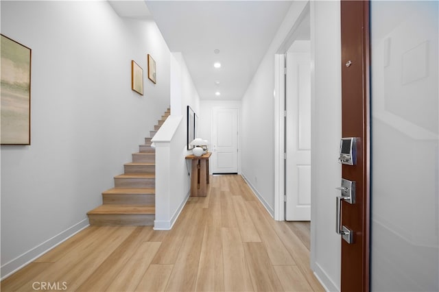 hallway with stairway, recessed lighting, baseboards, and light wood-style floors