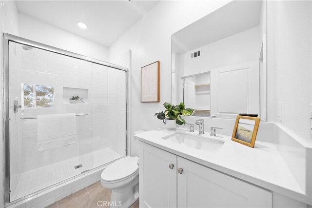full bathroom featuring toilet, a stall shower, tile patterned floors, visible vents, and vanity