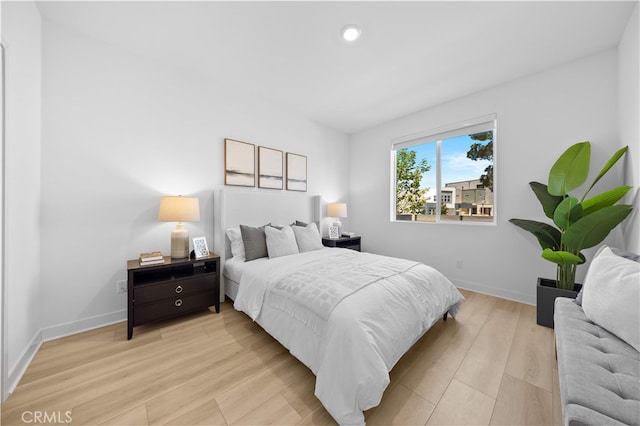 bedroom with baseboards, light wood-type flooring, and recessed lighting