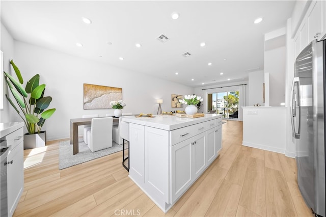 kitchen with freestanding refrigerator, recessed lighting, and white cabinetry