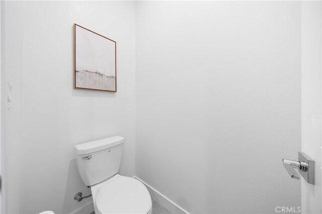 bathroom featuring toilet and baseboards