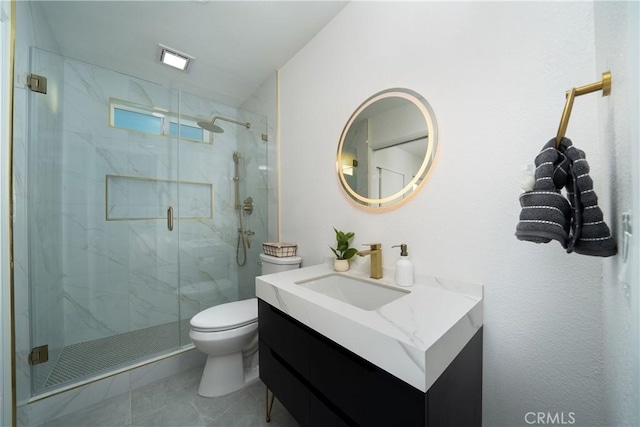 bathroom with a marble finish shower, vanity, and toilet