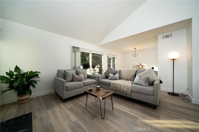 living area featuring baseboards, a notable chandelier, visible vents, and wood finished floors