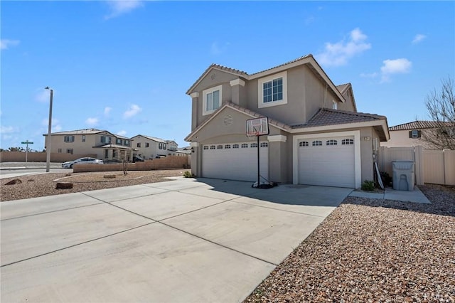 traditional-style home with a garage, a tile roof, fence, driveway, and stucco siding