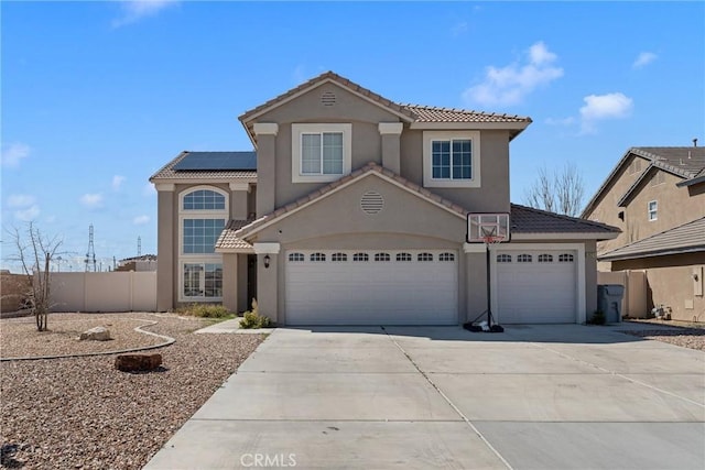 view of front of property with concrete driveway, stucco siding, an attached garage, and roof mounted solar panels