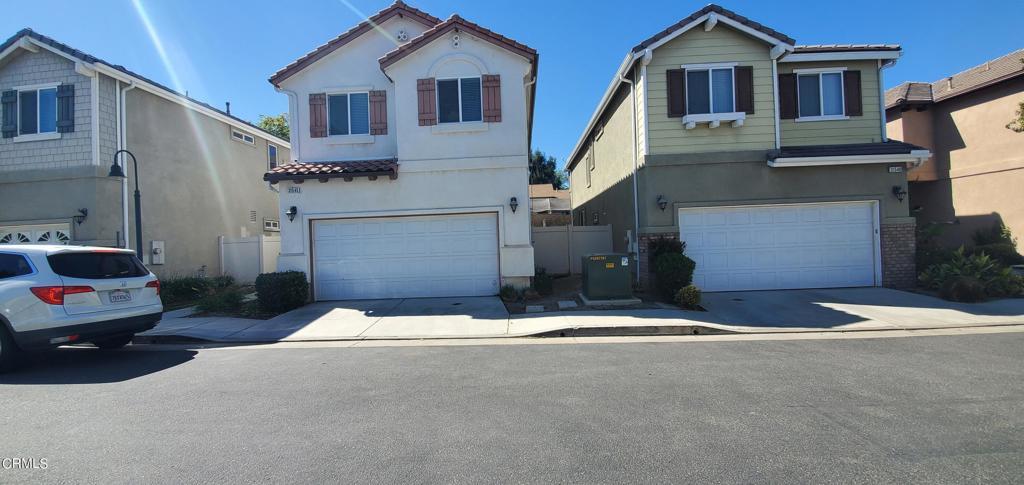 view of front of property featuring stucco siding, a tiled roof, concrete driveway, and a garage