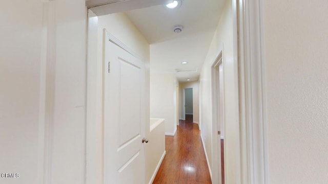 hall with baseboards, wood finished floors, and recessed lighting