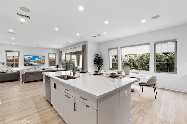 kitchen featuring a center island with sink, visible vents, plenty of natural light, a sink, and stainless steel dishwasher