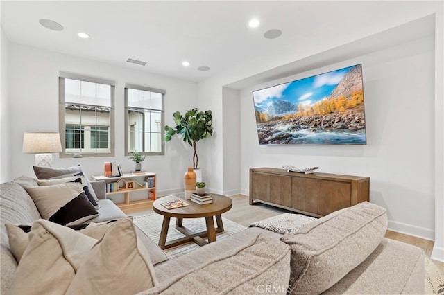 living room with recessed lighting, light wood-type flooring, baseboards, and visible vents